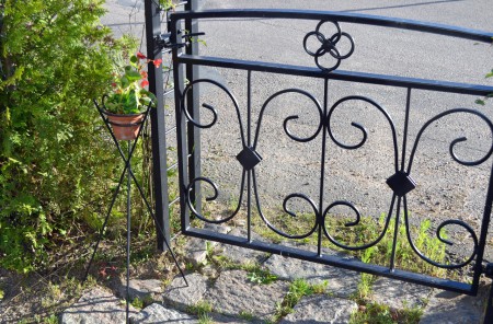 Liten smidesgrind och blomställ